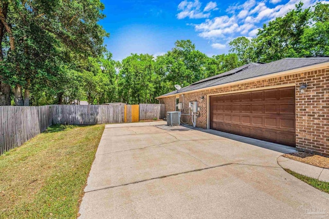 5649 Cane Syrup Cir, Pace, FL 32571 - view of side of property with driveway, solar panels, brick siding, a yard, and an attached garage