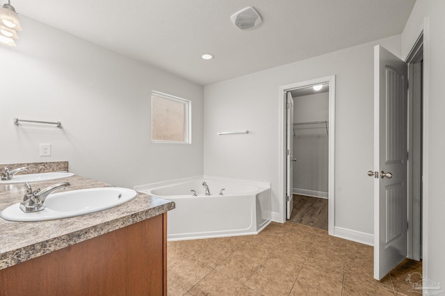 5649 Cane Syrup Cir, Pace, FL 32571 - full bathroom with a garden tub, a sink, baseboards, and a spacious closet