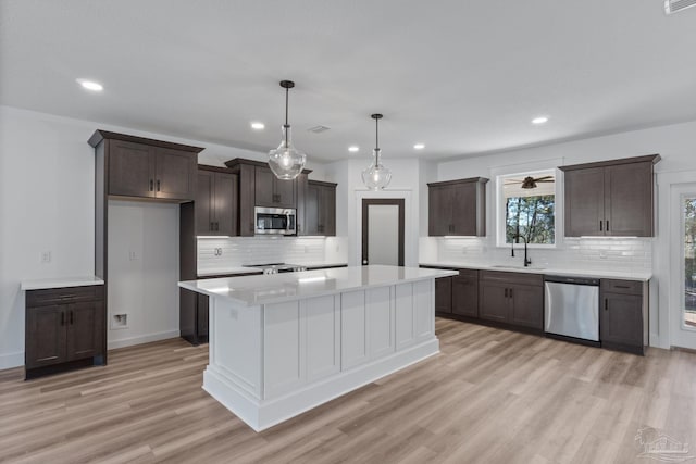 kitchen featuring light hardwood / wood-style floors, sink, stainless steel appliances, and decorative backsplash