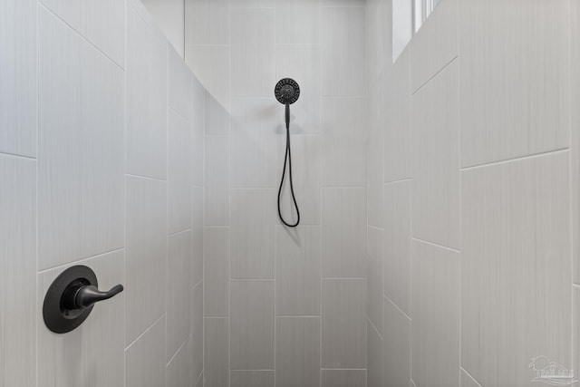 interior details featuring a tile shower