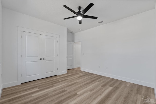 unfurnished bedroom with ceiling fan, a closet, and light hardwood / wood-style flooring