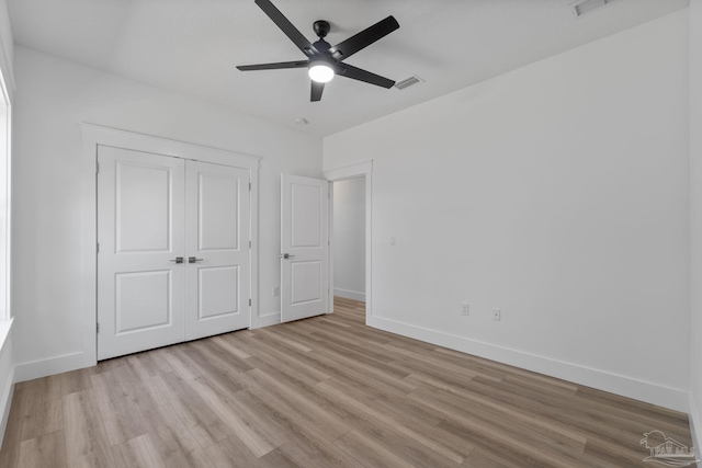 unfurnished bedroom featuring light wood-type flooring, ceiling fan, and a closet