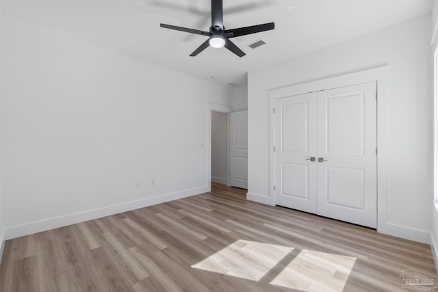 unfurnished bedroom featuring ceiling fan, light wood-type flooring, and a closet