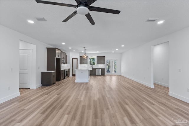 unfurnished living room with light wood-type flooring and ceiling fan