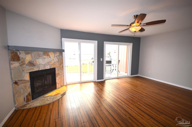 unfurnished living room featuring wood-type flooring, a fireplace, baseboards, and ceiling fan