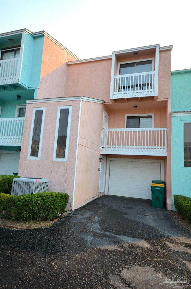 view of building exterior featuring a garage, driveway, and central AC unit