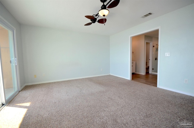 carpeted empty room featuring visible vents, ceiling fan, and baseboards