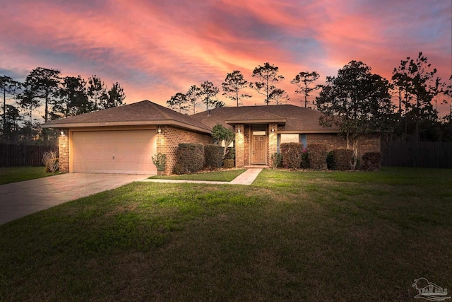 view of front of home featuring brick siding, a yard, concrete driveway, fence, and a garage