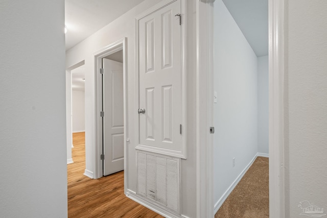 hall featuring baseboards and wood finished floors