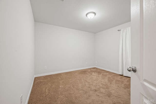 unfurnished room with carpet floors and baseboards