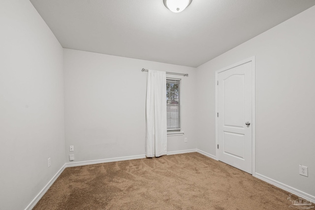 carpeted spare room with baseboards