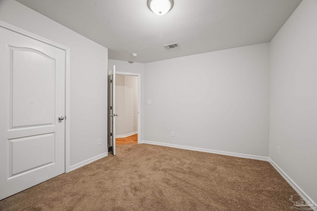 unfurnished bedroom with carpet, visible vents, and baseboards