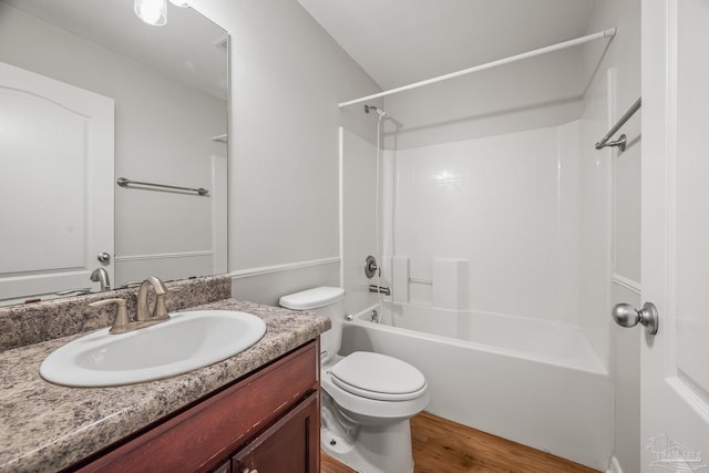 bathroom featuring toilet, bathing tub / shower combination, wood finished floors, and vanity