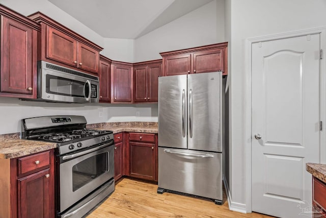 kitchen featuring reddish brown cabinets, light wood finished floors, and appliances with stainless steel finishes