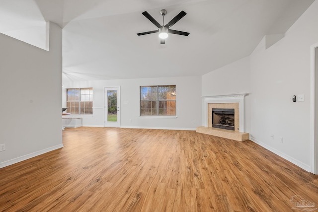 unfurnished living room featuring light wood-style floors, vaulted ceiling, a fireplace, and baseboards