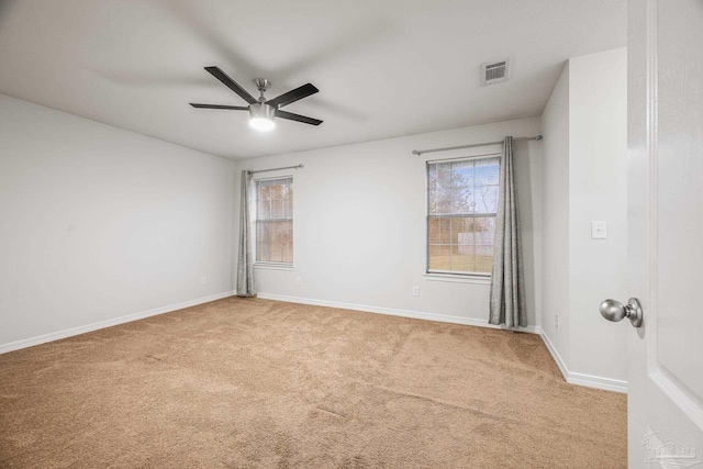 unfurnished room with plenty of natural light, carpet, visible vents, and baseboards