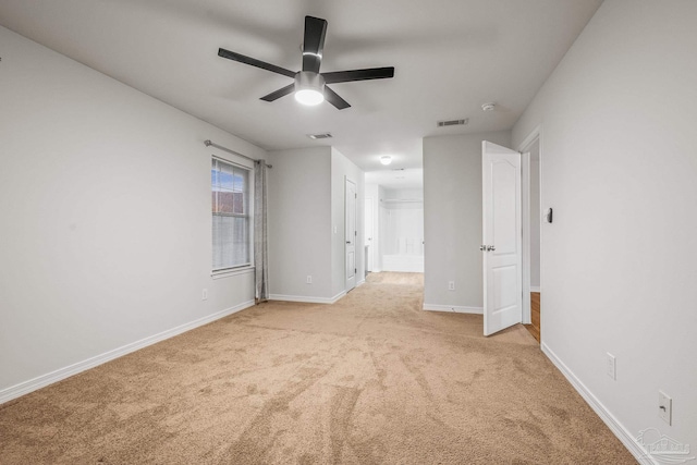 unfurnished bedroom with baseboards, ceiling fan, visible vents, and light colored carpet