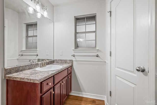 bathroom featuring wood finished floors, vanity, and baseboards