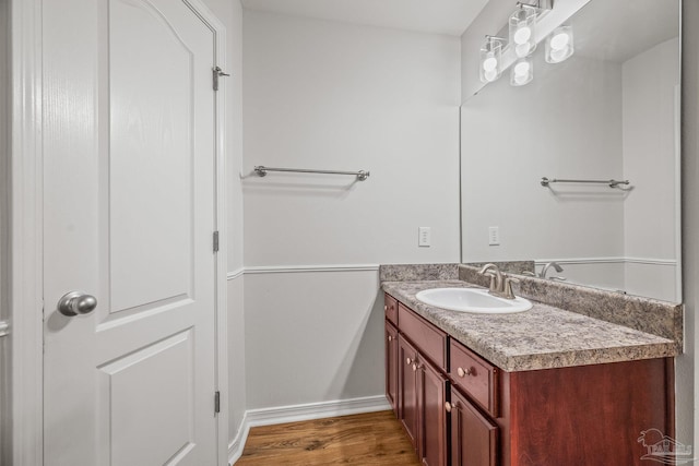 bathroom with vanity, baseboards, and wood finished floors