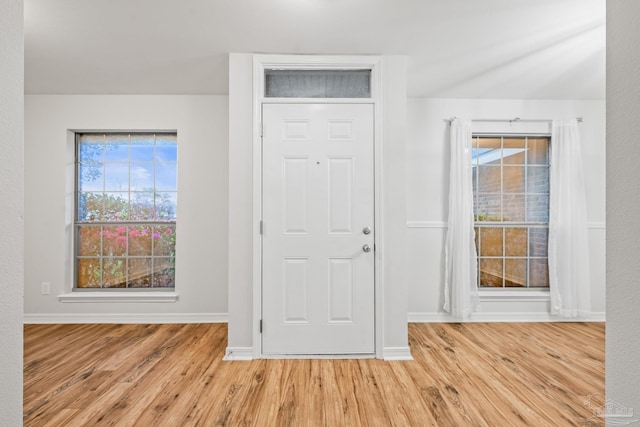 foyer featuring baseboards and wood finished floors