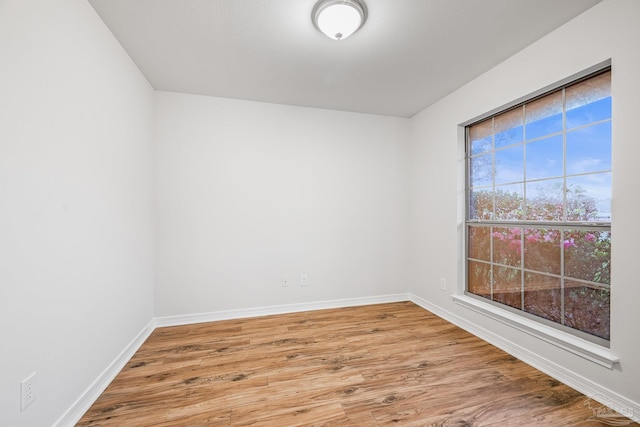 unfurnished room featuring light wood-type flooring and baseboards