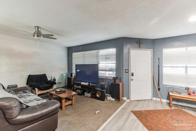 living room featuring a textured ceiling, ceiling fan, and light hardwood / wood-style floors