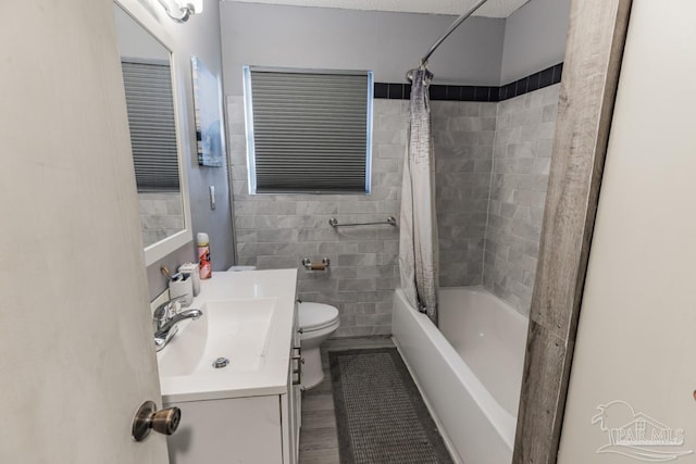 full bathroom featuring toilet, hardwood / wood-style flooring, shower / tub combo with curtain, and vanity