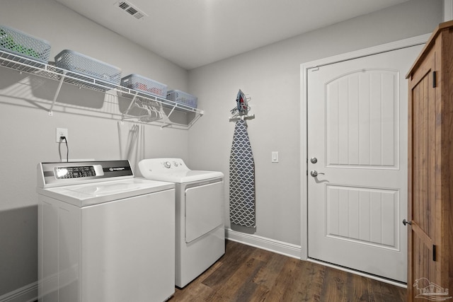 clothes washing area featuring dark hardwood / wood-style flooring and separate washer and dryer