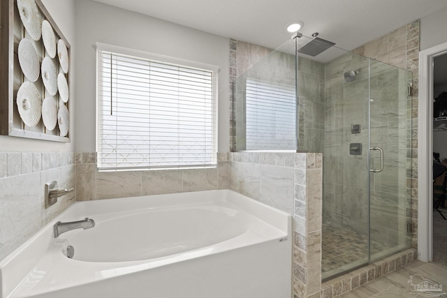 bathroom featuring shower with separate bathtub