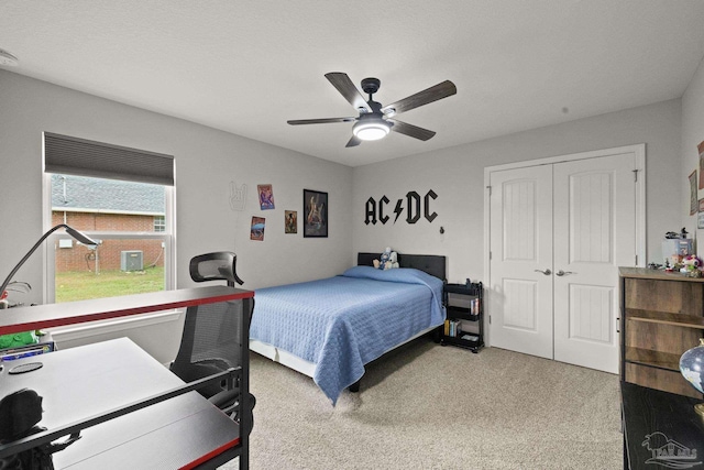 carpeted bedroom with ceiling fan and a closet