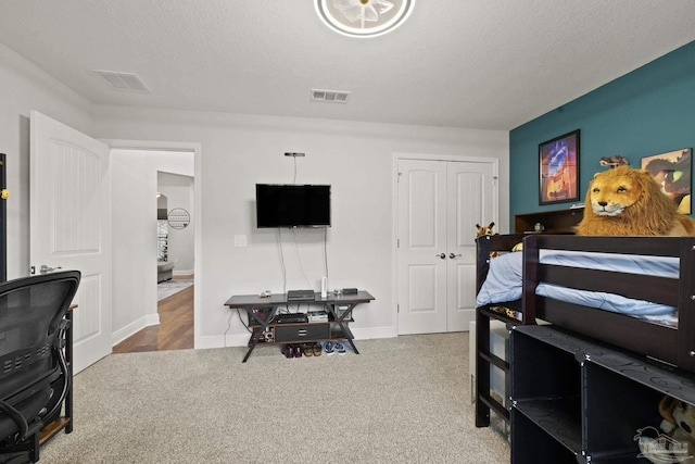 bedroom with carpet, a textured ceiling, and a closet