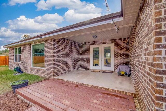 wooden terrace with french doors and a patio