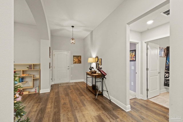 foyer entrance with dark hardwood / wood-style floors and a notable chandelier