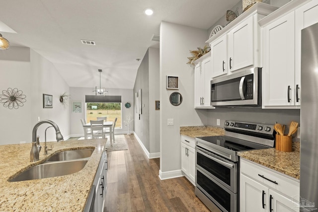 kitchen with white cabinetry, sink, decorative light fixtures, vaulted ceiling, and appliances with stainless steel finishes