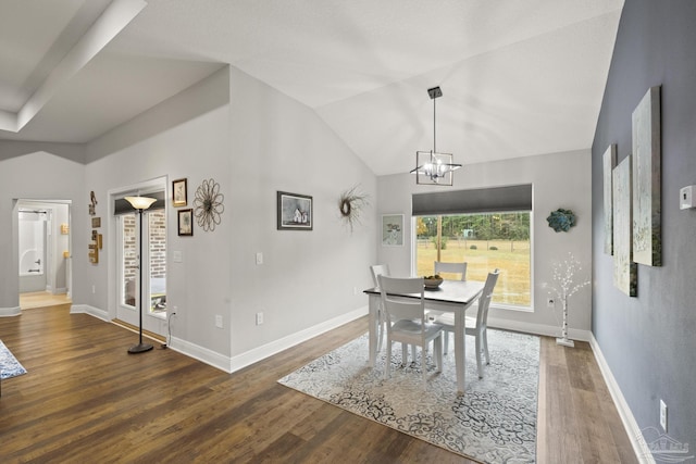 dining area featuring vaulted ceiling, dark hardwood / wood-style floors, and an inviting chandelier