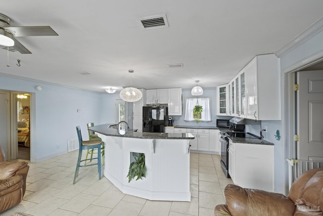 kitchen with white cabinetry, a center island, a kitchen breakfast bar, pendant lighting, and black appliances