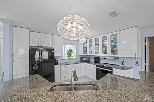 kitchen with electric stove, sink, pendant lighting, white cabinets, and black fridge with ice dispenser