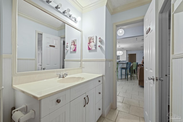 bathroom with crown molding, vanity, and tile patterned flooring