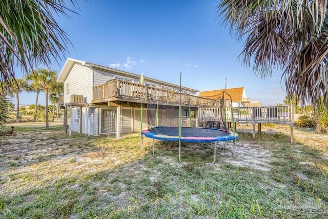 view of yard with a wooden deck and a trampoline