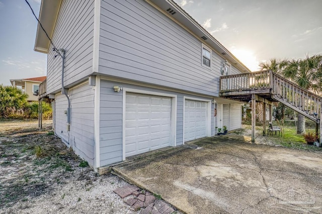 view of property exterior featuring a garage and a deck