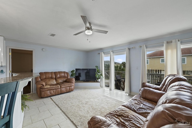 tiled living room with ornamental molding and ceiling fan