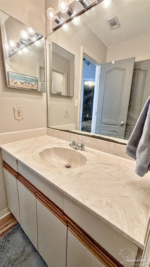 bathroom with vanity and a textured ceiling