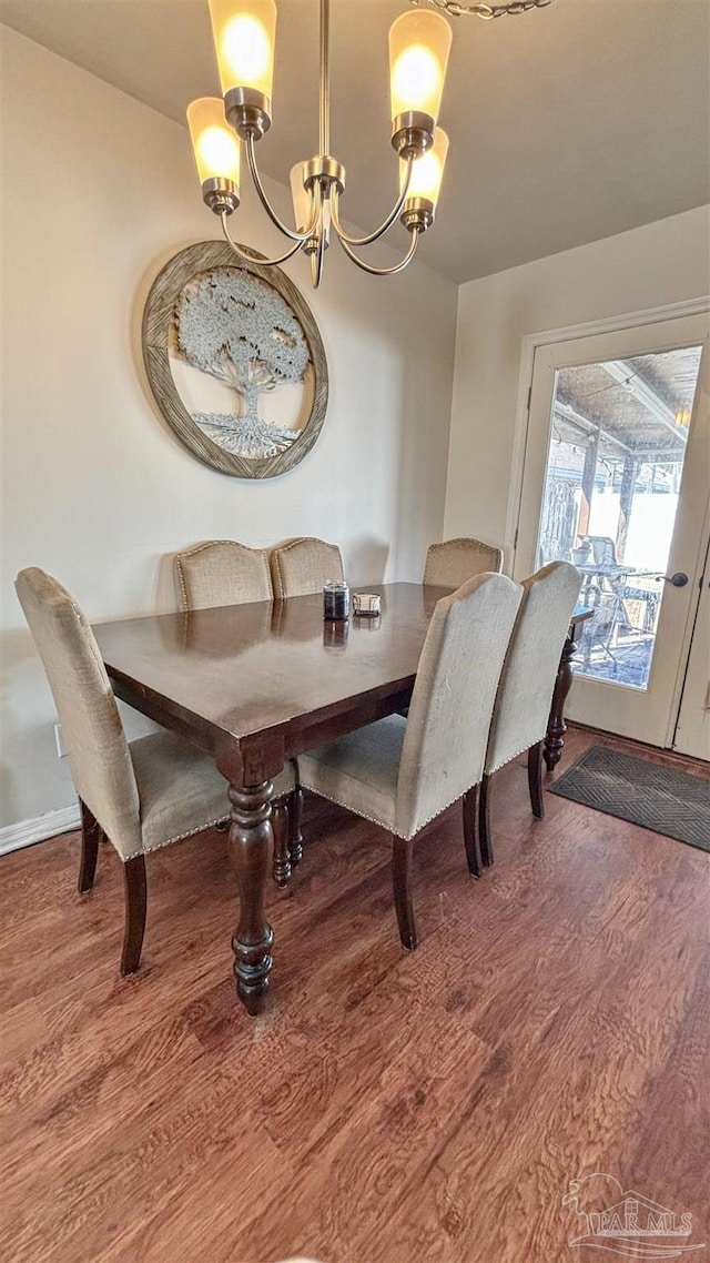 dining room featuring hardwood / wood-style floors and an inviting chandelier