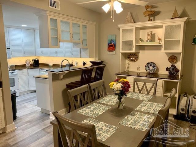 dining space with light hardwood / wood-style flooring and ceiling fan