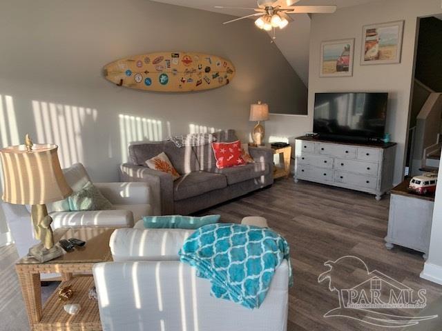 living room featuring ceiling fan and dark wood-type flooring