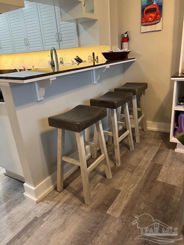 kitchen featuring a breakfast bar area and wood-type flooring