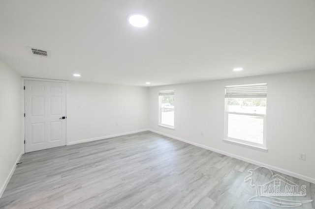 empty room featuring light wood-style flooring, baseboards, visible vents, and recessed lighting