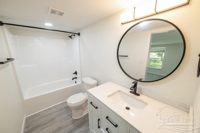bathroom featuring visible vents, toilet, bathtub / shower combination, vanity, and wood finished floors