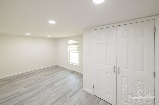 unfurnished bedroom with a closet, baseboards, light wood finished floors, and recessed lighting