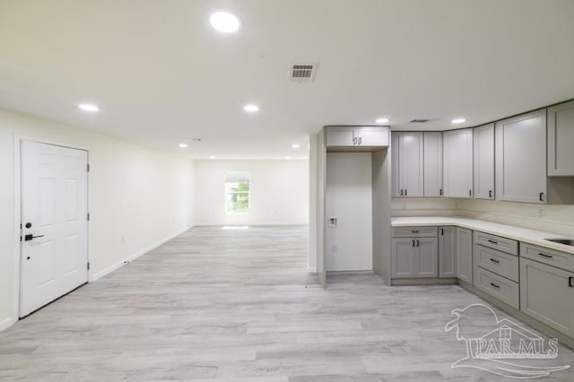 kitchen featuring gray cabinetry, light wood-style flooring, visible vents, recessed lighting, and baseboards